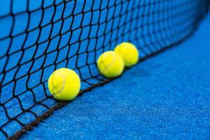 drei Paddel Tennis Ball in der Nähe von das Netz, Schläger Sport foto