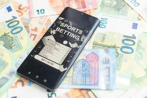 Dollar und Euro, Smartphone mit Sport Wette Anwendung foto