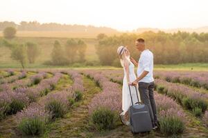 Mann und Frau mit Koffer im Lavendel Feld foto