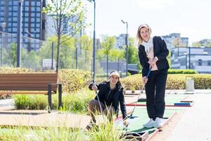 Mutter und Tochter spielen Mini Golf, Kinder genießen Sommer- Ferien foto