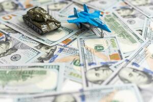 Spielzeug Panzer auf uns hundert Dollar Rechnungen Banknoten schließen hoch. das Konzept von Krieg Kosten, Militär- Ausgaben und wirtschaftlich Krise foto