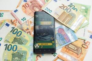 Dollar und Euro, Smartphone mit Sport Wette Anwendung foto