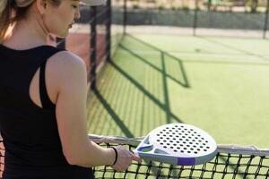 Frau Padel Tennis Spieler Ausbildung auf Gericht. Frau mit Schläger zu schlagen Ball. foto