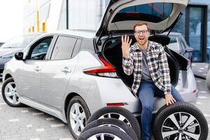 Auto Mechaniker Arbeiten im Auto Ausstellungsraum und Ändern Rad Legierung Reifen. Reparatur oder Instandhaltung Auto Service. foto