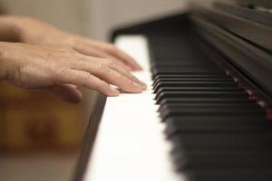 weibliche Hände spielen das E-Piano, Hand- und Klaviertasten hautnah foto