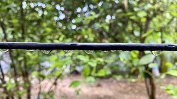 glitzernd Regentropfen auf ein Draht nach ein Sommer- Dusche foto