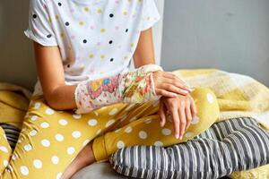 Teen Mädchen mit ein gebrochen Arm beim Zuhause ein orthopädisch Besetzung foto