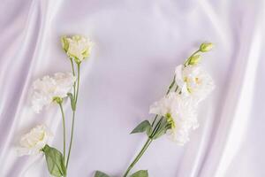 abstrakt Weiß Hintergrund von Seide Wellen von Weiß Stoff. zart Hintergrund. das Konzept von ein Hochzeit oder Hochzeit Dekor. Weiß frisch Blumen. foto