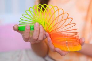 Kind spielen Orange und Grün eng, bunt flexibel Kinder- Spielzeug, Spaß Plastik Spielzeug. Teen Mädchen Theaterstücke aufreizend foto