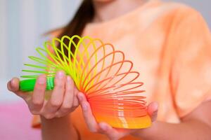 Kind spielen Orange und Grün eng, bunt flexibel Kinder- Spielzeug, Spaß Plastik Spielzeug. Teen Mädchen Theaterstücke aufreizend foto