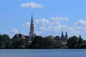 Abonnieren Stadt, Dorf Panorama einschließlich das Schloss Turm, das Kirche Türme und das in der Nähe Teich auf ein sonnig Tag foto