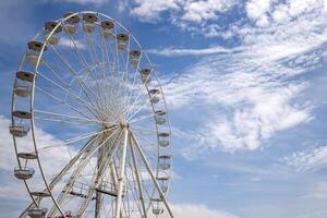 Ferris Rad ein Amüsement Park Jahrmärkte Attraktion mit ein wolkig Blau Himmel foto