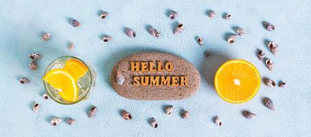 Konzept Hallo Sommer- Text auf Stein, Cocktail, Orange und Muscheln auf Blau oben Aussicht Netz Banner foto