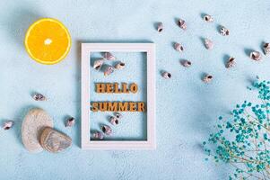 Hallo Sommer- Text im Foto rahmen, orange, Steine, getrocknet Blumen und Muscheln auf Blau oben Aussicht