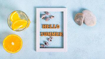 Hallo Sommer- Text und Muscheln im Foto rahmen, Cocktail und Orange auf Blau oben Aussicht Netz Banner