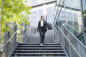 zuversichtlich Geschäftsfrau absteigend draussen Treppe foto