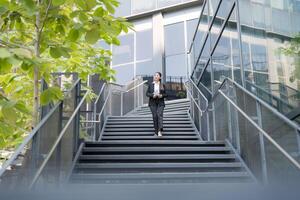 zuversichtlich Geschäftsfrau absteigend draussen Treppe foto