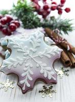 Weihnachtslebkuchen mit Weihnachtsschmuck auf weißem Holz foto