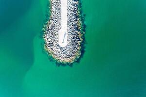 Antenne Zenit Drohne Aussicht von ein Wellenbrecher im ein Meer von Türkis Wasser foto