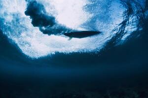 Surfer auf Surfbrett im Ozean unter Wasser. abstürzen Welle und Surfbrett im transparent Wasser foto