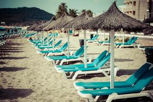 Deck Stühle Über das Sand im ein idyllisch Strand im Ibiza, balearisch Inseln, Spanien foto