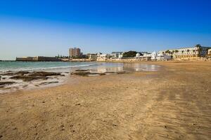 alt Badehaus auf das Strand von 'la caleta', einer von das die meisten berühmt Websites im das Stadt von Cádiz, Spanien foto