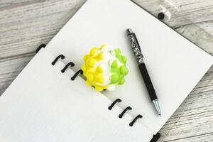 Notizblock Tagebuch mit Stift und Anti-Stress Ball auf das Desktop foto