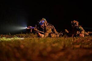 Soldaten im tarnen Uniformen Zielen mit ihr Gewehre bereit zu Feuer während Militär- Betrieb beim Nacht Soldaten Ausbildung im ein Militär- Betrieb foto