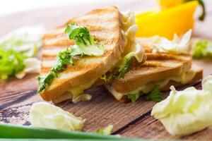 gebraten Toast mit Füllung, Salat Blätter, Tomaten foto