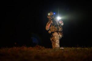 Soldaten bereit zu Feuer während Militär- Betrieb beim Nacht foto