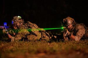 Soldaten bereit zu Feuer während Militär- Betrieb beim Nacht foto