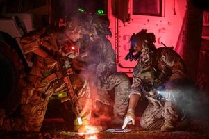 Soldaten im tarnen Uniformen Zielen mit ihr Gewehre bereit zu Feuer während Militär- Betrieb beim Nacht, Soldaten Ausbildung im ein Militär- Betrieb foto