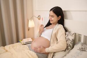 schön schwanger Frau halten positiv Schwangerschaft prüfen, Fruchtbarkeit Unfruchtbarkeit Behandlung, In-vitro-Fertilisation, Zukunft Mutterschaft Konzept foto