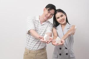 glücklich Paar von Liebe halten klein Haus Über Weiß Hintergrund foto