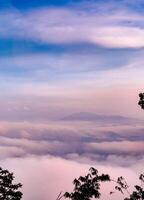 das atemberaubend Aussicht von ein Touristen Standpunkt wie Sie gehen Nieder ein Hügel auf ein nebelig Weg mit ein Hügel und ein Hintergrund von ein golden Himmel im Wald Park, Thailand. Regenwald. Vogel Auge Sicht. Antenne Sicht. foto