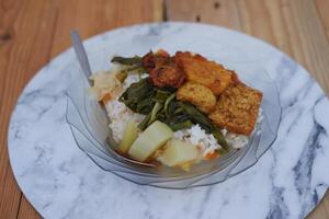 Reis mit gebraten Hähnchen und Gemüse auf ein Teller im ein Restaurant foto
