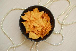 Tortilla Chips im ein Schüssel mit Perlen auf das Tabelle foto