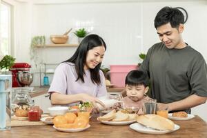 Familie Zeit, Frühstück, Aktivitäten zusammen während das Feiertage. Eltern und Kinder sind haben ein Mahlzeit zusammen während das Feiertage. Neu Zuhause zum Familie auf Morgen, genießen, Wochenende, vakant Zeit foto