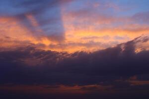 ein Sonnenuntergang Himmel mit Wolken und ein lila Himmel mit ein wenige Wolken. foto