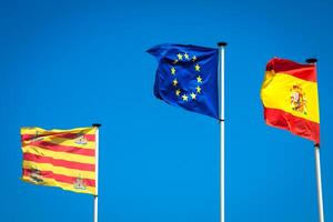 Spanisch und europäisch Flaggen winken im das Wind foto