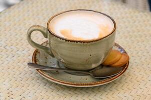 Tasse von Latté Kaffee und Löffel auf grau Zähler foto