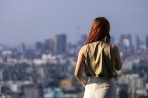 Luxus jung asiatisch Vorsitzender Frau Unternehmer Stehen auf das Dach suchen zu das Geschäft Innenstadt Aussicht mit Wolkenkratzer und Stadtbild auf das Hintergrund Konzept foto