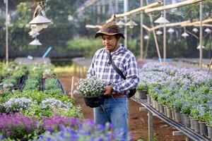 jung asiatisch Gärtner ist wählen blühen Pflanze von das lokal Garten Center Kindergarten voll von Sommer- Pflanze zum Wochenende Gartenarbeit und draussen Hobby Konzept foto