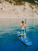 kann 15, 2021. Anapa, Russland. sportlich Frau auf Stand oben Paddel Tafel beim Blau Meer. Surfer Frau auf sup Tafel im Sommer- Meer. Antenne Aussicht foto