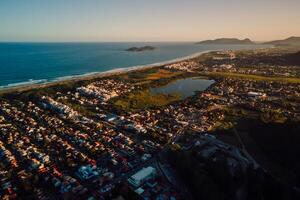 Küste mit Ozean und Stadt, Dorf mit Sonnenuntergang Töne im Campeche, florianopolis foto