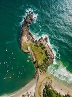 Antenne Aussicht von Küste mit felsig Insel, Strand und Ozean mit Boote im Brasilien. Matadero Strand und ponta das Campanhas foto