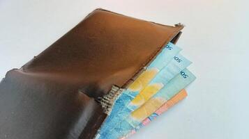 schließen oben braun Brieftasche gefüllt mit Geld foto