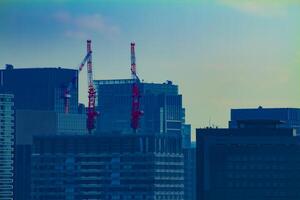 ziehen um Kräne beim oben von das Gebäude im Tokyo lange Schuss foto