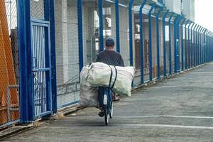 ein Farmer oder Assgeier Wer Transporte Waren im Säcke mit ein Fahrrad, Indonesien, 23 kann 2024. foto