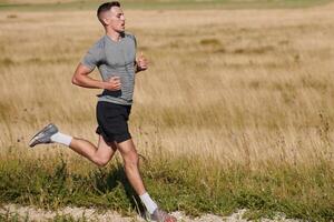 entschlossen schreiten. sportlich Mann begibt sich auf Marathon- Vorbereitung mit lösen. foto